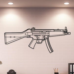 May include: Black metal wall art depicting the outline of a submachine gun. The artwork is mounted on a white brick wall above a wooden desk. The gun's design includes a stock, magazine, and trigger.