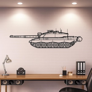 May include: Black metal wall art depicting a detailed outline of a tank. The artwork features a long barrel, a detailed turret, and visible treads. The tank is mounted on a white brick wall, creating a striking contrast.