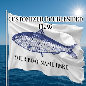 May include: A white, double-sided flag featuring a blue fish design. The flag displays the text "CUSTOMIZED DOUBLESIDED FLAG" and "YOUR BOAT NAME HERE". The background shows a blue ocean and sky with a bright sun.
