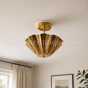 Könnte beinhalten: Eine goldfarbene Deckenleuchte mit gewelltem Rand. Die Leuchte ist auf einer weißen, kreisförmigen Basis montiert und hat einen zentralen Stiel. Der Text "Ultimate Antique Store" ist auf dem Bild sichtbar.