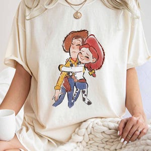 A woman wearing a white t-shirt with a cartoon illustration of two characters from the Toy Story movie.