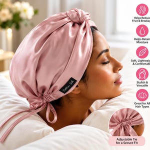 May include: A dusty pink silk hair bonnet featuring a knotted top detail and an adjustable tie closure at the base for a secure fit. A small black fabric label with the white text Boldiva Silk is attached to the side of the bonnet.