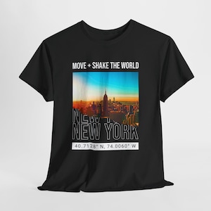 May include: Black t-shirt with a vibrant image of the New York City skyline at sunset. The shirt displays the text "MOVE + SHAKE THE WORLD" above the image, and "NEW YORK" below it, along with the coordinates 40.7128° N, 74.0060° W.