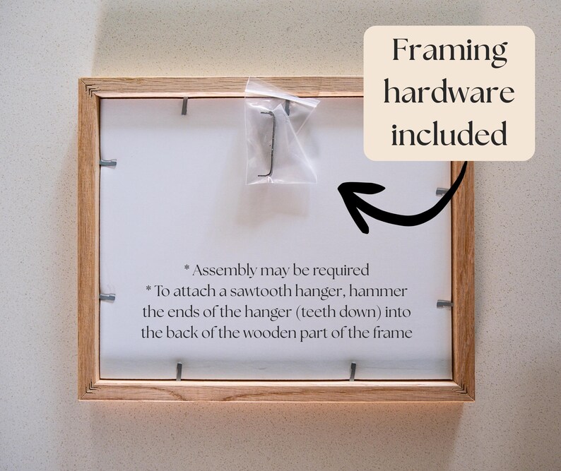 Op de afbeelding: Een rechthoekige fotolijst van lichtgekleurd hout, getoond vanaf de achterkant met metalen clips die de achterplaat vastzetten. Een klein plastic zakje met een zaagtandhanger is bevestigd. Tekst: Framing hardware included, Assembly may be required.