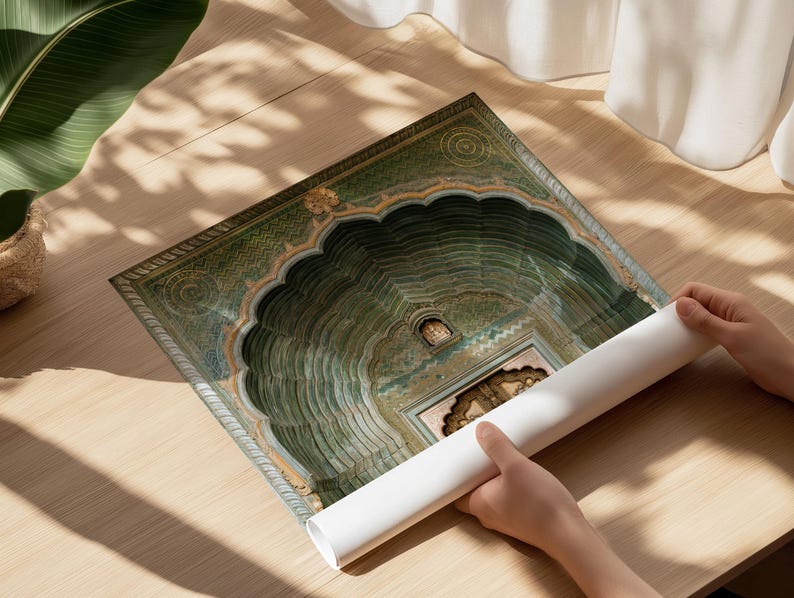 Op de afbeelding: Een opgerolde papieren print met een gedetailleerde architecturale illustratie van een groene boogingang met ingewikkelde patronen en een centrale deur. Het kunstwerk toont een reeks concentrische, geschulpte treden die naar een terugliggende ingang leiden.