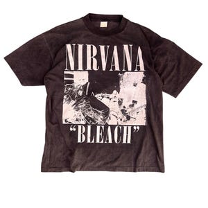 Könnte beinhalten: Dunkelgraues T-Shirt mit dem Bandnamen "NIRVANA" über einem Schwarz-Weiß-Bild und dem Wort "BLEACH" in Weiß. Das T-Shirt hat kurze Ärmel und einen Rundhalsausschnitt.