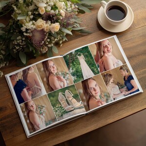 May include: An open photo album featuring a collage of wedding images, including a white dress, high-heeled sandals, and portraits of a person. The album is placed on a wooden surface next to a bouquet of white and purple flowers and a cup of coffee.