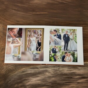 May include: An open photo album featuring a collection of wedding photographs. The pages display various scenes including a person applying makeup, a bride in a mirror, and several portraits of a couple in formal attire outdoors in a park.