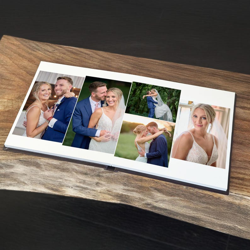 May include: A photo album open to a spread featuring five wedding photographs. The images display a couple in formal attire, including a white wedding dress and a blue suit, captured in various poses during an outdoor wedding ceremony and portrait session.