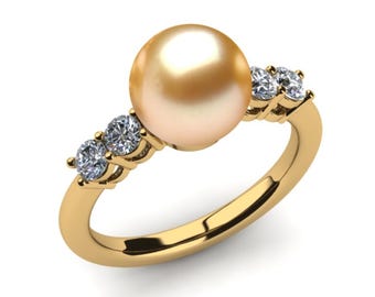 Può includere: Un anello in oro con una grande perla dorata, rotonda e lucente al centro. La fascia è realizzata in oro giallo lucido ed è decorata su ciascun lato da due piccoli diamanti bianchi rotondi, chiari e sfaccettati in montature di metallo.