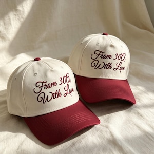 Pode incluir: Dois bon&eacute;s de beisebol com copa cor de creme e aba vermelho-escura. Cada bon&eacute; tem o texto bordado "From 30A With Love" em letra cursiva vermelho-escura no painel frontal. Os bon&eacute;s possuem um bot&atilde;o no topo e ilh&oacute;s costurados.