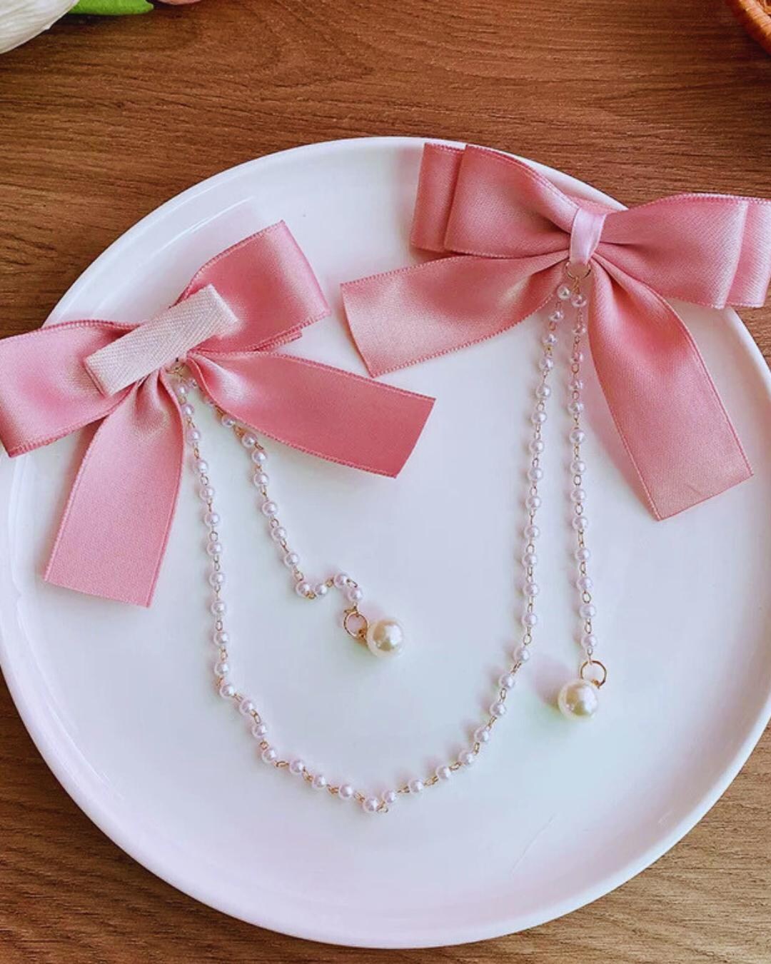 スイートなプリンセススタイルのピンクのパールチェーンボウヘア 