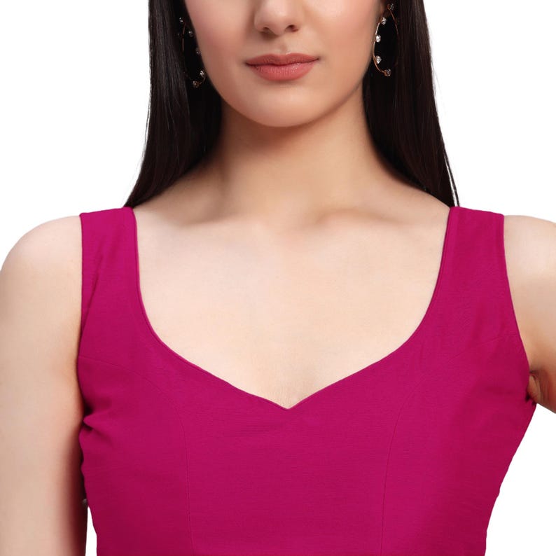 Puede incluir: Un top magenta sin mangas con cuello en V. El top est&aacute; hecho de una tela suave y tiene un dise&ntilde;o simple y elegante. El top es de color liso y es adecuado para diversas ocasiones.