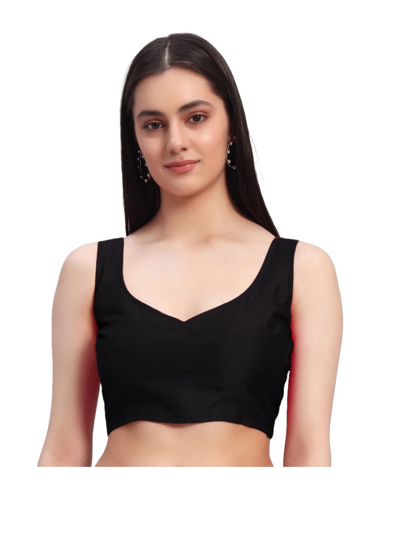 Puede incluir: Una blusa negra sin mangas con cuello en V. La blusa est&aacute; hecha de una tela oscura y lisa. La imagen es un primer plano de la blusa, que muestra el escote y la textura de la tela. La blusa es una prenda b&aacute;sica.