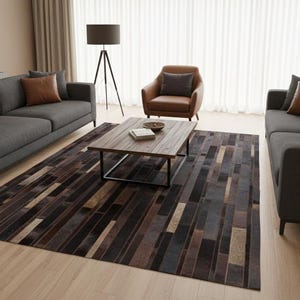 May include: A modern living room setup featuring two dark gray sofas with brown accent pillows, a leather armchair, and a wooden coffee table. A patterned rug in shades of brown and gray covers the floor.