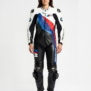 May include: A white, black, and blue BMW motorcycle racing suit. The suit features a white upper body with black sleeves and a black lower body. Blue and red stripes run down the front. The BMW logo is visible on the chest and sleeves.