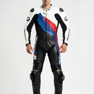 May include: A black, white, and blue leather motorcycle racing suit. The suit features the BMW Motorrad logo and a color block design with red and blue stripes. The suit has protective padding on the shoulders and knees.