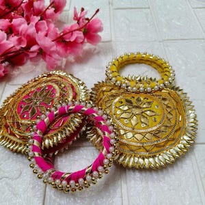 May include: A white ceramic mug with a black handle and the text "But First, Coffee" in a black, handwritten-style font. The mug is on a white surface.