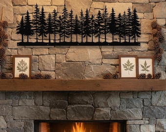 May include: Black metal forest silhouette wall art. The artwork depicts a row of pine trees. The art is mounted above a wooden mantel, with framed botanical prints and pine cones. The fireplace is made of stone.
