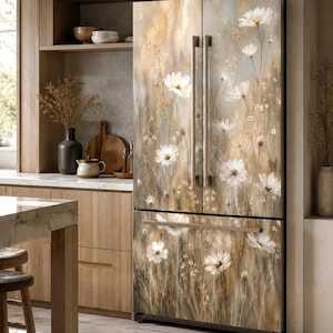 May include: A French door refrigerator featuring a wrap-around artistic print of white cosmos flowers and tall grasses in muted beige, brown, and soft gray tones. The appliance has vertical metallic handles and a bottom freezer drawer.