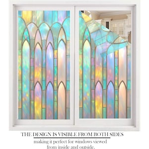 May include: A white window frame with two panes of iridescent window film. The film features a stained-glass design with arched shapes in shades of blue, yellow, and purple. Text at the bottom reads: "THE DESIGN IS VISIBLE FROM BOTH SIDES".