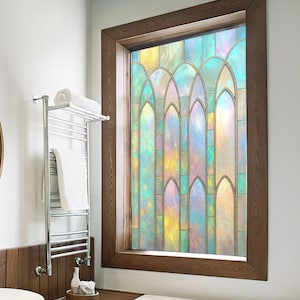 May include: A stained glass window with a wooden frame. The window features a colorful design with shades of blue, yellow, and green. The window is in a bathroom setting, with a towel rack and a wooden accent wall.