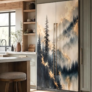 May include: A double-door refrigerator featuring a full-length artistic print of a misty forest landscape with dark blue pine trees and golden highlights. The appliance has two vertical metallic handles and is integrated into a kitchen cabinetry wall.