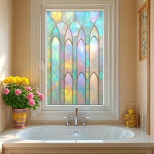 May include: A stained glass window with a colorful, iridescent design is the focal point of this bathroom. The window's pattern features arched shapes and vertical lines, with a palette of blues, greens, yellows, and pinks. A white bathtub and a potted plant are in the foreground.