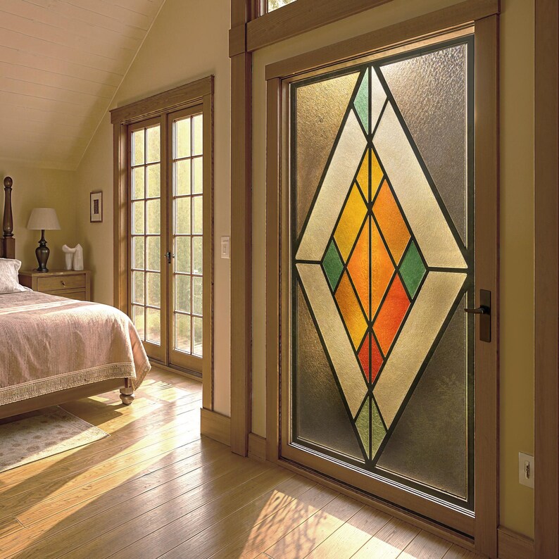 Puede incluir: Una puerta de vidriera con un dise&ntilde;o geom&eacute;trico en un dormitorio. El dise&ntilde;o presenta una gran forma de diamante con segmentos naranjas, amarillos, verdes y blancos. La puerta est&aacute; enmarcada en madera y la habitaci&oacute;n tiene pisos de madera.