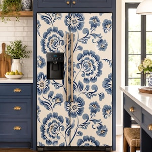 May include: A double-door refrigerator featuring a cream-colored surface adorned with a repeating pattern of large, stylized blue flowers and swirling leaves. The appliance includes two vertical metallic handles and a black water dispenser.
