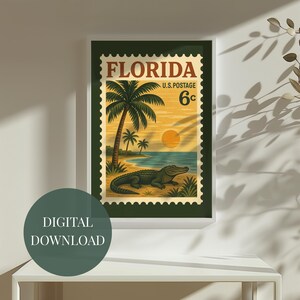 May include: A framed vintage-style print featuring a Florida postage stamp design. The artwork showcases a beach scene with palm trees, an alligator, and a sunset. The text "FLORIDA" and "U.S. POSTAGE 6&cent;" are prominently displayed.