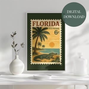 May include: A framed digital print featuring a vintage Florida stamp design. The artwork showcases a beach scene with palm trees, an alligator, and a sunset. The stamp reads "Florida U.S. Postage 6c".