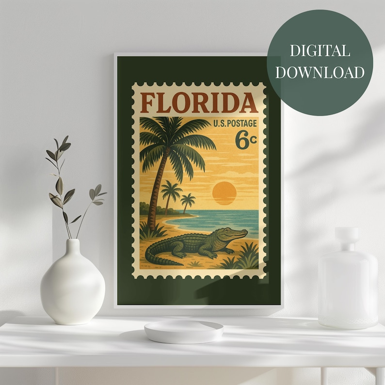 May include: A framed digital print featuring a vintage Florida stamp design. The artwork showcases a beach scene with palm trees, an alligator, and a sunset. The stamp reads "Florida U.S. Postage 6c".