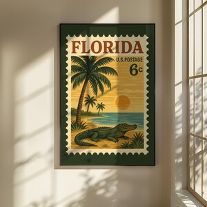 May include: Framed vintage-style print of a Florida postage stamp. The design features a palm tree, beach, ocean, and a green alligator. The text "FLORIDA U.S. POSTAGE 6c" is printed at the top. The frame is dark green.