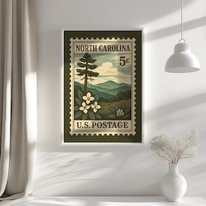 May include: A rectangular wall art print featuring a vintage-style postage stamp design. The stamp displays the text NORTH CAROLINA and U.S. POSTAGE with a 5c denomination. It depicts a mountain landscape, a tall pine tree, and white flowers.