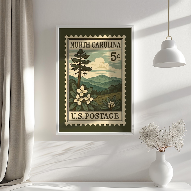 May include: A rectangular wall art print featuring a vintage-style postage stamp design. The stamp displays the text NORTH CAROLINA and U.S. POSTAGE with a 5c denomination. It depicts a mountain landscape, a tall pine tree, and white flowers.