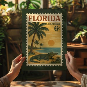 May include: A vintage-style print featuring a Florida postage stamp design. The artwork showcases a beach scene with palm trees, an alligator, and the text "FLORIDA U.S. POSTAGE 6&cent;". The print has a dark green border.