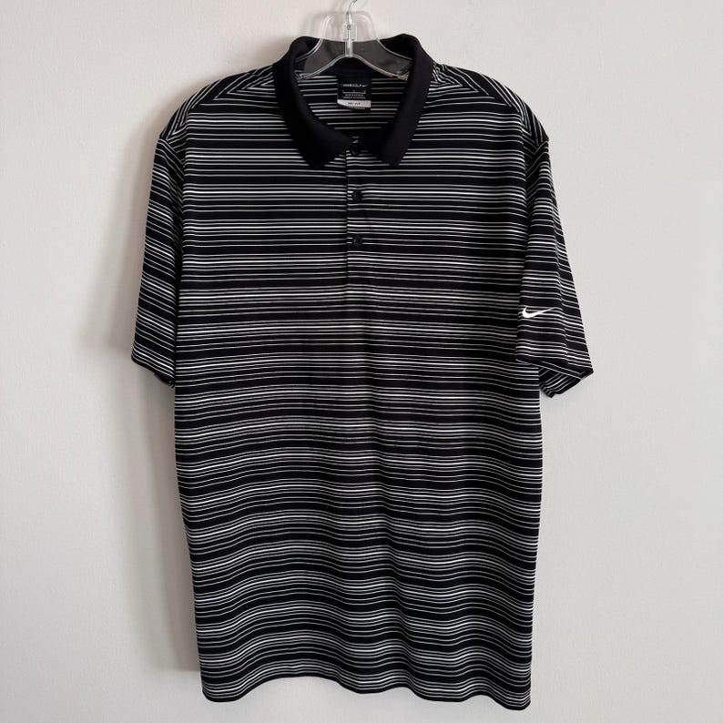 Polo Nike Golf Dri Fit para hombre, talla L, negro, blanco, rayas Swoosh. imagen 1