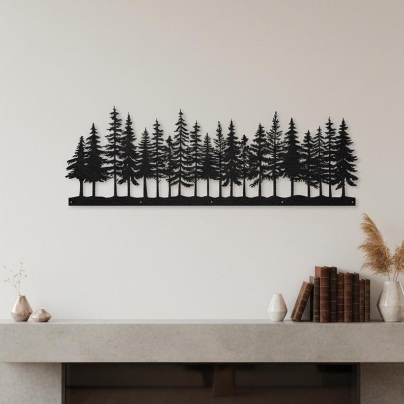 May include: Black metal wall art depicting a forest of pine trees. The silhouette of the trees is mounted on a white wall above a fireplace. The artwork adds a natural, rustic touch to home decor.