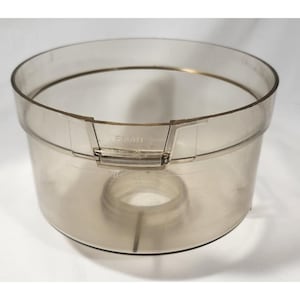 Peut inclure: Un bol de robot culinaire en plastique transparent avec un design circulaire. Le bol a une large ouverture et une apparence légèrement teintée. Le mot "FRONT" est visible sur le côté du bol.