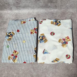 Juego de 2 sábanas vintage para cuna Springmaid con estampado de osito de peluche y rayas azules para habitación infantil.