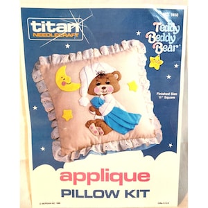 Puede incluir: Un kit de almohada con diseño de oso de peluche. El kit incluye una almohada beige con borde con volantes, un oso de peluche con gorro de dormir y sosteniendo una manta, una luna y estrellas amarillas. Tamaño final: 28 cm cuadrados.