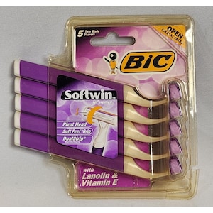 Puede incluir: Un paquete de cinco maquinillas de afeitar de doble hoja BIC Softwin para mujer. El envase es de plástico morado y transparente, con el logotipo de BIC y la información del producto. Las maquinillas tienen mangos morados y cuchillas blancas.