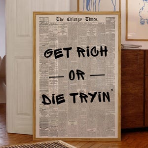 May include: A framed print of a vintage newspaper page from The Chicago Times. Bold black text overlays the newspaper, reading "GET RICH OR DIE TRYIN'" in a handwritten style. The frame is a light wood color.