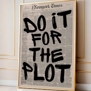 May include: A framed print featuring a vintage newspaper background with the words "DO IT FOR THE PLOT" in bold black lettering. The print is in a gold frame, adding a touch of elegance to the motivational message. The newspaper is dated June 21.