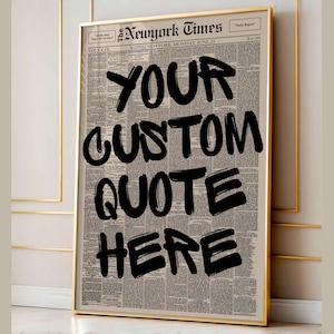Op de afbeelding: Een ingelijste print met een vintage krantenachtergrond en een gouden lijst. De tekst 'YOUR CUSTOM QUOTE HERE' is in dikke zwarte letters geschreven. Een decoratief item voor aan de muur.