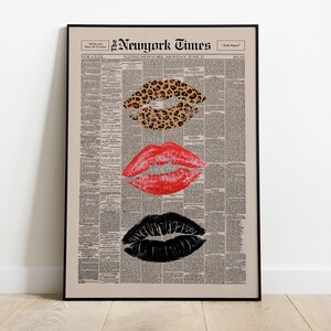 May include: A framed print featuring three sets of lips in different styles. The top lip print has a leopard print pattern, the middle lips are red, and the bottom lips are black. The background is a vintage newspaper print with the text "The New York Times".