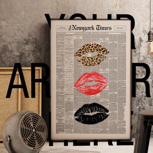 May include: A framed print featuring three sets of lips in leopard print, red, and black, set against a vintage newspaper background. The print is titled "The New York Times" and dated June 21.