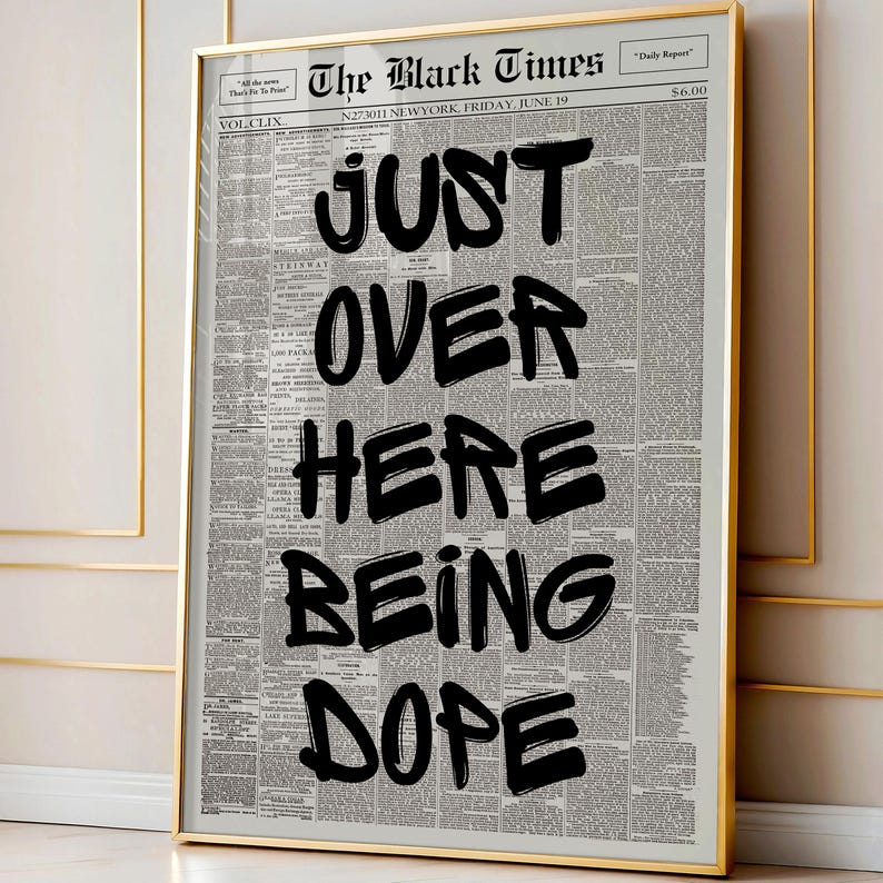 Puede incluir: Una l&aacute;mina enmarcada que muestra una p&aacute;gina de peri&oacute;dico de estilo vintage titulada The Black Times. El texto JUST OVER HERE BEING DOPE est&aacute; impreso en letras negras grandes y llamativas con trazo de pincel sobre columnas de texto gris.