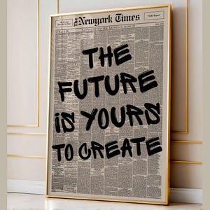 May include: Framed print featuring a vintage newspaper background with the headline "The Future Is Yours To Create" in bold black lettering. The print is encased in a gold frame.